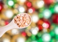 Spoon with candies on Colorful Christmas balls, abstract background. Royalty Free Stock Photo