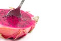 Closeup of a spoon in a red dragon fruit cut in half isolated on a white background Royalty Free Stock Photo