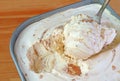 Closeup of a Spoon Scooping Delectable Caramel Macadamia Nut Ice Cream in the tub