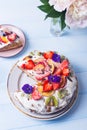 Closeup spring homemade sour cream fruit cake with coconut and chocolate flakes, kiwi,strawberry and peach, decorated with flowers Royalty Free Stock Photo