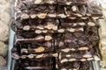 Closeup stack of assortment luxury handmade chocolate, dark chocolate bars with nuts in shop window. Selective focus