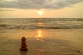 Stack of balanced pebble stones on the sunset beach against splashing waves Royalty Free Stock Photo