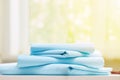 Closeup stack of blue clean bedding on blurred background. Sunlight from the window Royalty Free Stock Photo