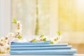 Closeup stack of blue clean bedding on a dresser. Blurred background.