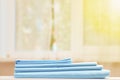 Closeup stack of blue clean bedding on the table. Blurred background. Window Royalty Free Stock Photo