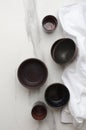 Vertical image.Top view of clay bowels and cups on the white marble table, white napkin