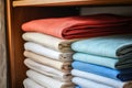closeup stack of colorful towels on shelf. folded linen towels are white, blue, red Royalty Free Stock Photo