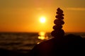 Stack of different stones in balance at the beach sunset