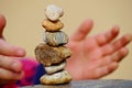 Stack of different stones in balance with child`s hands