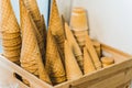 Closeup of stack of empty waffle ice cream cones in an Ice cream shop in wooden container.