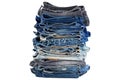 Stack of folded blue jeans pants, dark blue denim trousers showing waistbands.