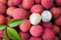 Closeup of stack of pink Lychee fruits and wet green leaves