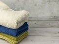 Closeup of stacked colorful rolled towels on a wooden table in bathroom with copyspace Royalty Free Stock Photo