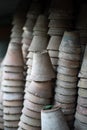 Closeup of stacks of old used weathered terra cotta flower pots in gardening shed