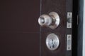 Closeup stainless steel knob, brown wooden door lock. The image is partially clear Royalty Free Stock Photo