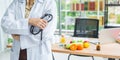 Closeup of standing asian nutritionist doctor woman holding stethoscope