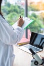 Closeup standing asian nutritionist doctor woman writing on paper