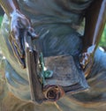 Closeup of statue hands holding book bookmarked with a rose Royalty Free Stock Photo