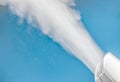 closeup steam from the air humidifier on blue background. health, disease prevention