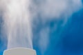 closeup steam from the air humidifier on blue background. health, disease prevention