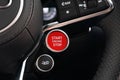 Closeup of Steering wheel start stop button of Red Audi R8 Sport Plus