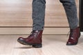Closeup of stepping woman legs in red leather boots and black jeans Royalty Free Stock Photo