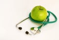 Closeup on stethoscope and apple on table