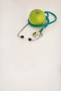 Closeup on stethoscope and apple on table