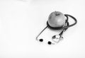 Closeup on stethoscope and apple on table