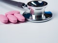 Closeup, stethoscope and pink pills .