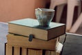 Closeup of healthy herbal cup of tea at a pile of old dusty books Royalty Free Stock Photo