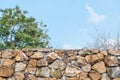 Closeup stone brick fence with blurred tree and blue sky textured background Royalty Free Stock Photo