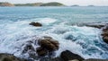 Closeup with a stony beach splashing water and swash wave, forming a spray. Sea waves crashing against the rocks.Aerial view of Royalty Free Stock Photo