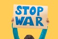 Closeup stop war sign against yellow background. woman protest slogan.