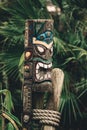 Closeup of a strange and frightful man figure of the totemism with the background of a fir tree