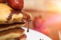 Closeup of a strawberry dripping chocolate syrup