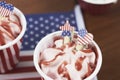 Closeup of strawberry sundaes on top of the America flag on a wooden table