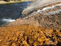Closeup of stream of steaming water flowing into river at Yellowstone National Park Royalty Free Stock Photo