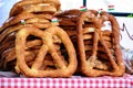 closeup of street food display stand with tasty golden brown salty cheese sprinkled Bavarian Pretzels