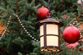 Closeup of street lantern and red christmas balls with LED garland on decorated natural New Year tree on a festive Christmas fair Royalty Free Stock Photo