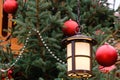 Closeup of street lantern and red christmas balls with LED garland on decorated natural New Year tree on a festive Christmas fair Royalty Free Stock Photo