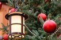 Closeup of street lantern and red christmas balls with LED garland on decorated natural New Year tree Royalty Free Stock Photo