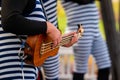 Closeup of a street musician playing the ukulele in a park Royalty Free Stock Photo