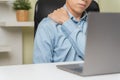 Closeup stressed young businessman massaging stiff shoulder neck when overworked. Exhausted tired office worker using computer Royalty Free Stock Photo