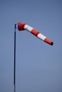 Closeup of striped windsock waiving in the wind against bright blue sky