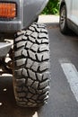 Closeup of front tire of four-wheel-drive car parked on asphalt in the city