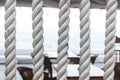Closeup of strong string white ropes on background sea and deck. Abstract sailor marine backdrop. Textured twisted
