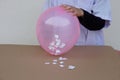 Science experiment about static electricty from balloon and pieces of paper. Royalty Free Stock Photo