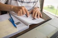 Closeup of student hand using eraser on workbook while studying Royalty Free Stock Photo