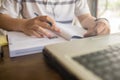 Closeup of student hand using pen while studying on workbook Royalty Free Stock Photo